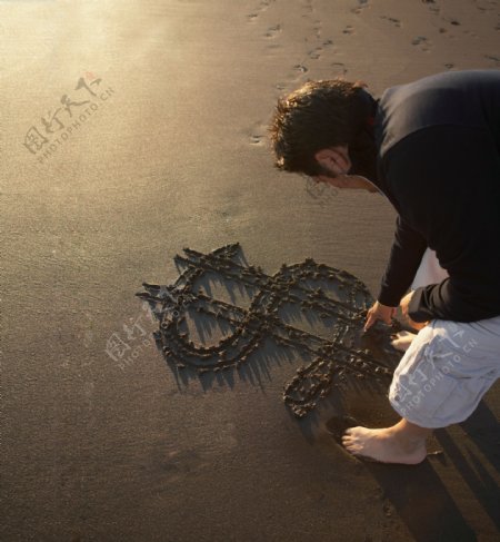男人在沙滩上写字图片