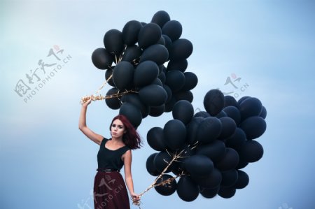 拿黑色气球的时尚美女图片
