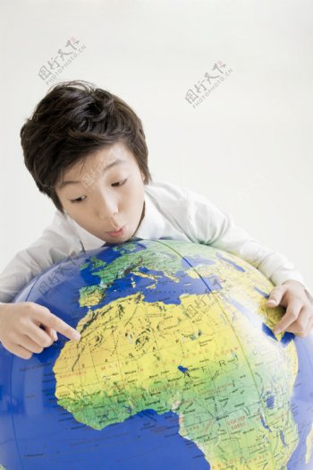 观看地球仪的可爱男孩图片