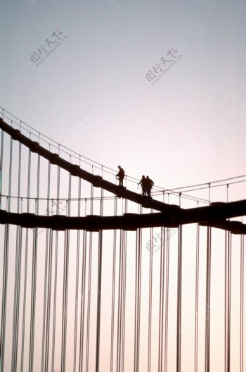 天桥上攀登的三个人图片