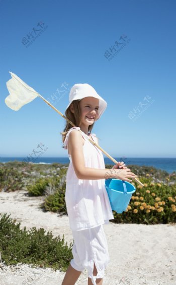 海边拿着捞鱼工具的小女孩图片