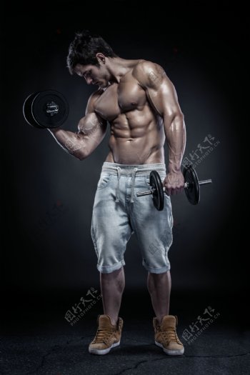 用哑铃展示肌肉的男人图片