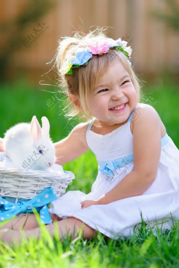 草丛上抱着兔子的女孩图片