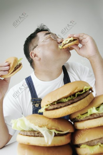 正在吃汉堡包的男人图片