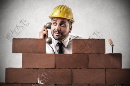 砌砖墙的建筑工人打电话图片