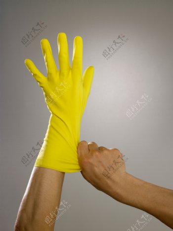 戴着黄色胶皮手套的手部特写图片图片