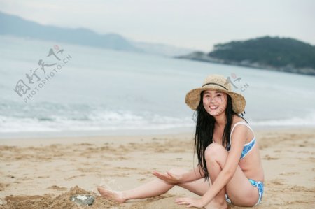 坐在海边沙滩上的美女图片