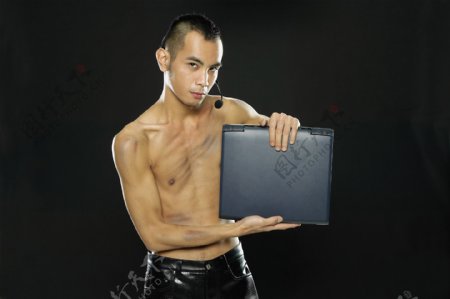 手捧笔记本电脑的青年男性图片