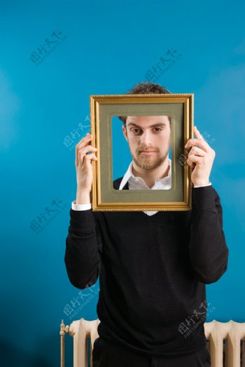 手拿画框的外国男性图片