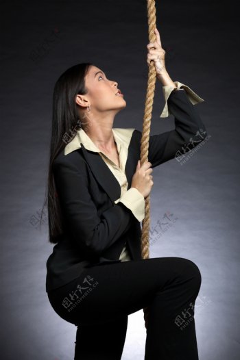 拉着麻绳往上爬的女人图片