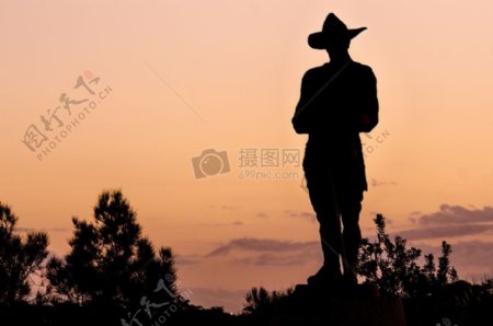 站在夕阳下戴帽子的男人