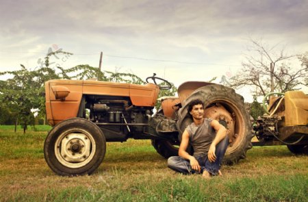 坐在拖拉机旁的农民图片