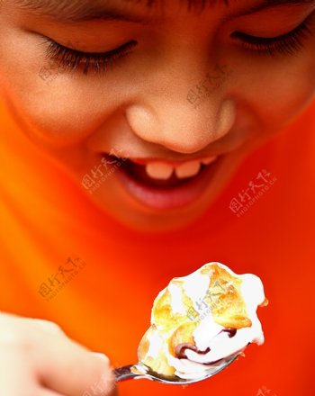 男孩正在吃美味的奶油泡芙