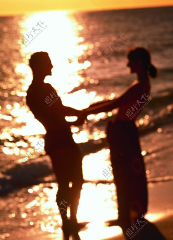 夕阳下的海滩情侣图片