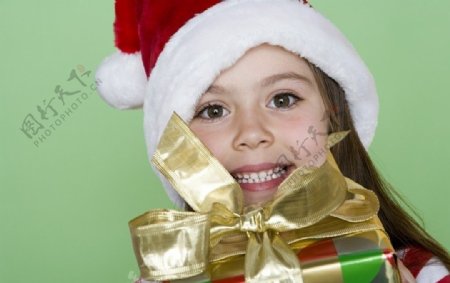 带圣诞帽捧着礼盒的漂亮小女孩图片