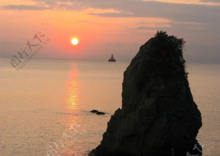 夕阳大海倒影礁石孤独暮色远帆图片