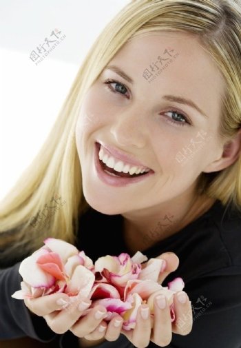 手捧美容鲜花的微笑美女图片