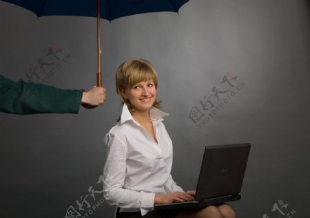 雨伞下工作的商务美女商务特写图片