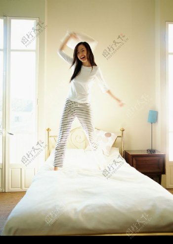 在床上蹦跳的女孩儿图片