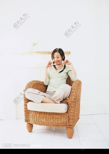 坐在藤条椅上的调皮女孩儿图片