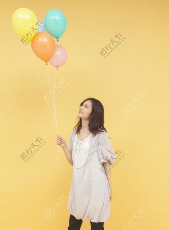拿着彩色气球的快乐女大学生图片