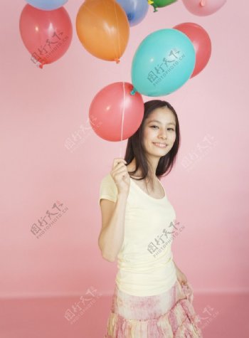 拿着彩色气球的女大学生图片