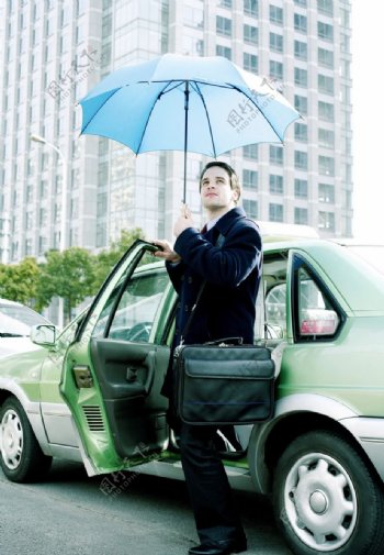 打雨伞遮阳下出租车的商务人物图片
