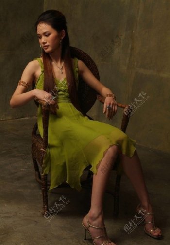 绿色无袖裙装美女椅子室内写真图片