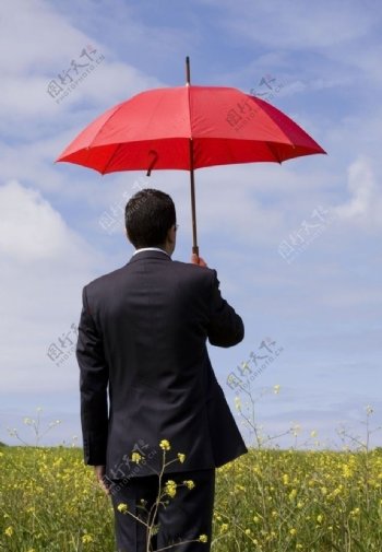 撑红伞在等待的男子图片
