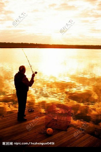 夕阳下海边钓鱼的老人图片