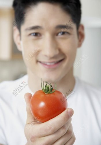 手拿西红柿的男人图片