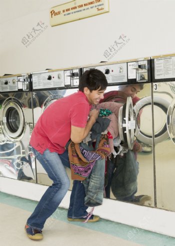 往洗衣机里塞衣服的男人图片