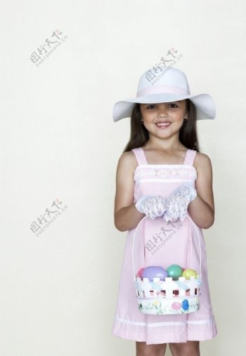 提着彩蛋小篮子的灿烂小女孩图片