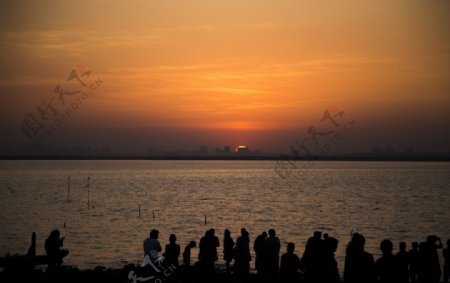 夕阳下海滩人群剪影