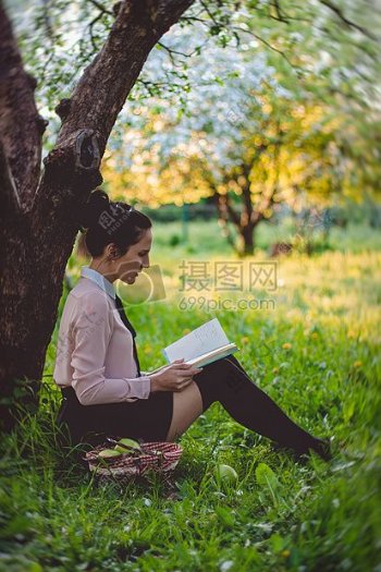 女子读一本书下的树