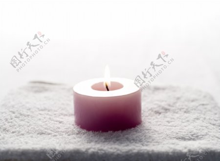 放在毛巾上燃烧的蜡烛写真图片图片