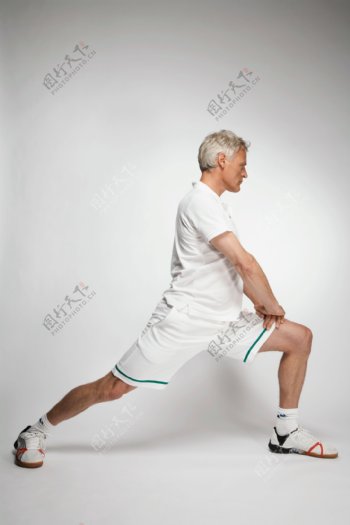 正在压腿运动的外国健康老人图片