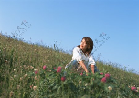 蹲在草地上的美女图片