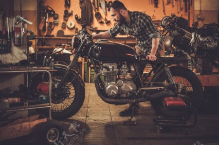 维修摩托车的男人图片