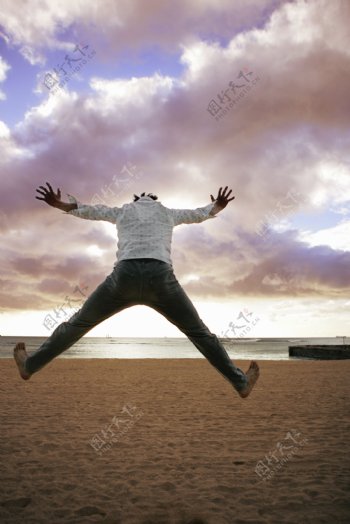 沙滩跳跃的男人图片