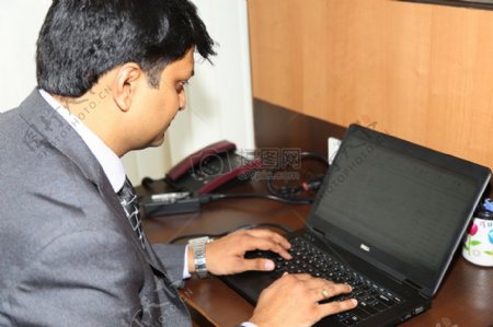 年轻商人正在电脑上办公