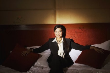 高级酒店床上坐着的职业女性图片