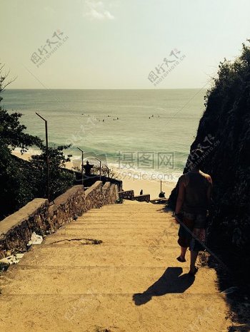 人穿着背心白天信步走过楼梯山海滨附近