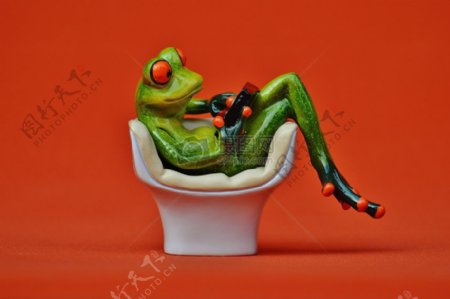 座椅上玩平板的青蛙