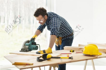 电锯锯木板的外国男性图片