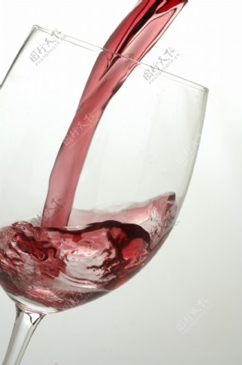 往杯里倒葡萄红酒时摄影图片