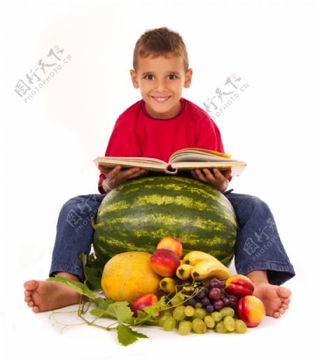 坐在水果边上看书的小男孩图片