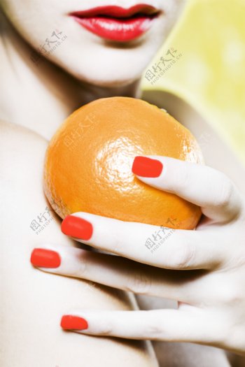 皮肤白皙的女人拿着橙子图片