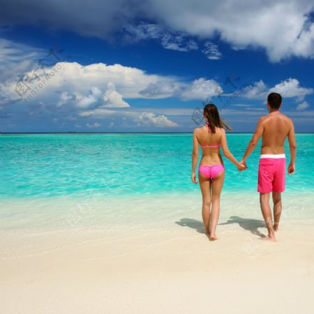 牵手走在沙滩的情侣图片