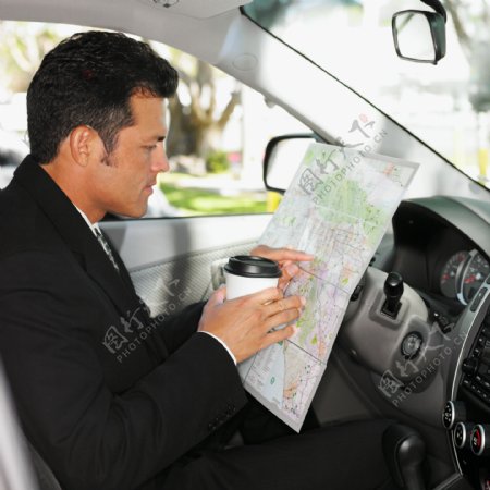 车内手拿咖啡看地图的男人图片